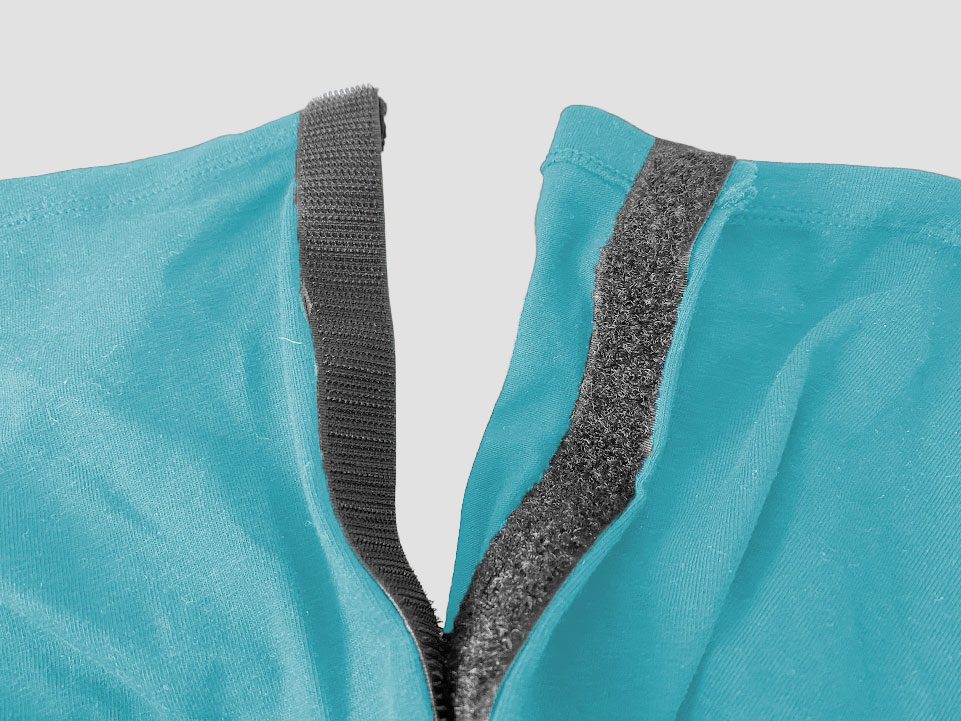 Image contains a light blue best with the sides split apart with two black Velcro pieces attached.