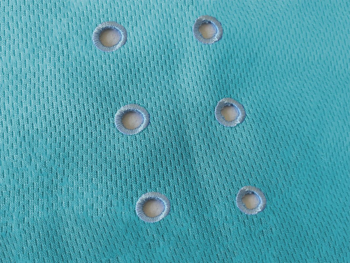 Image contains a shade of light blue fabric with 3 pairs of holes going through the fabric and down the center of the image, evenly spaced out.